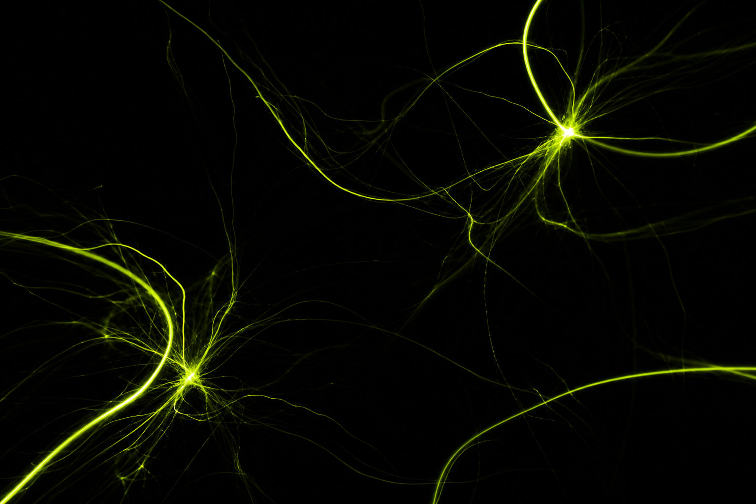 Streaks of green light tracing paths through darkness
