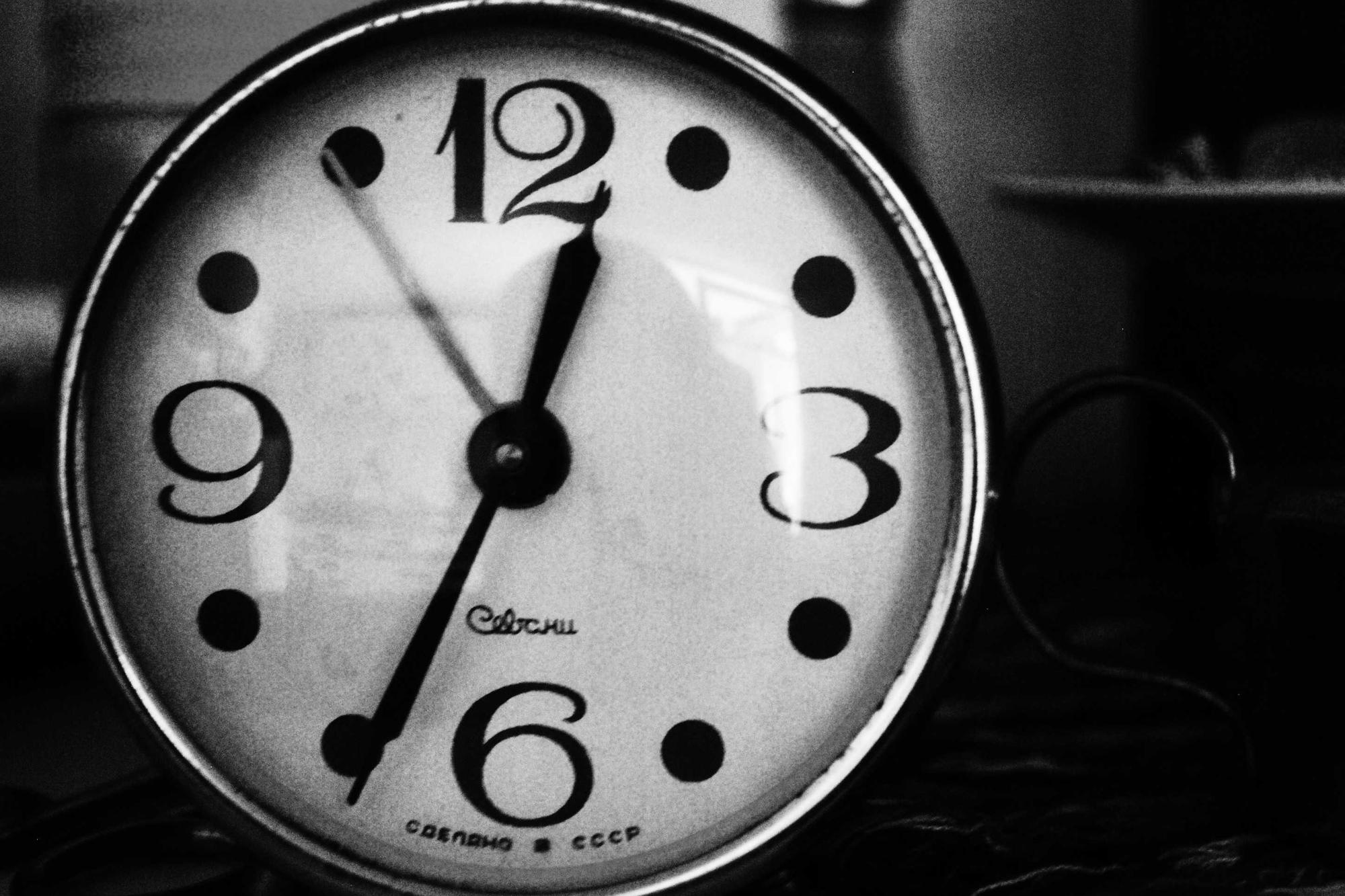 A black and white clock face showing almost seven