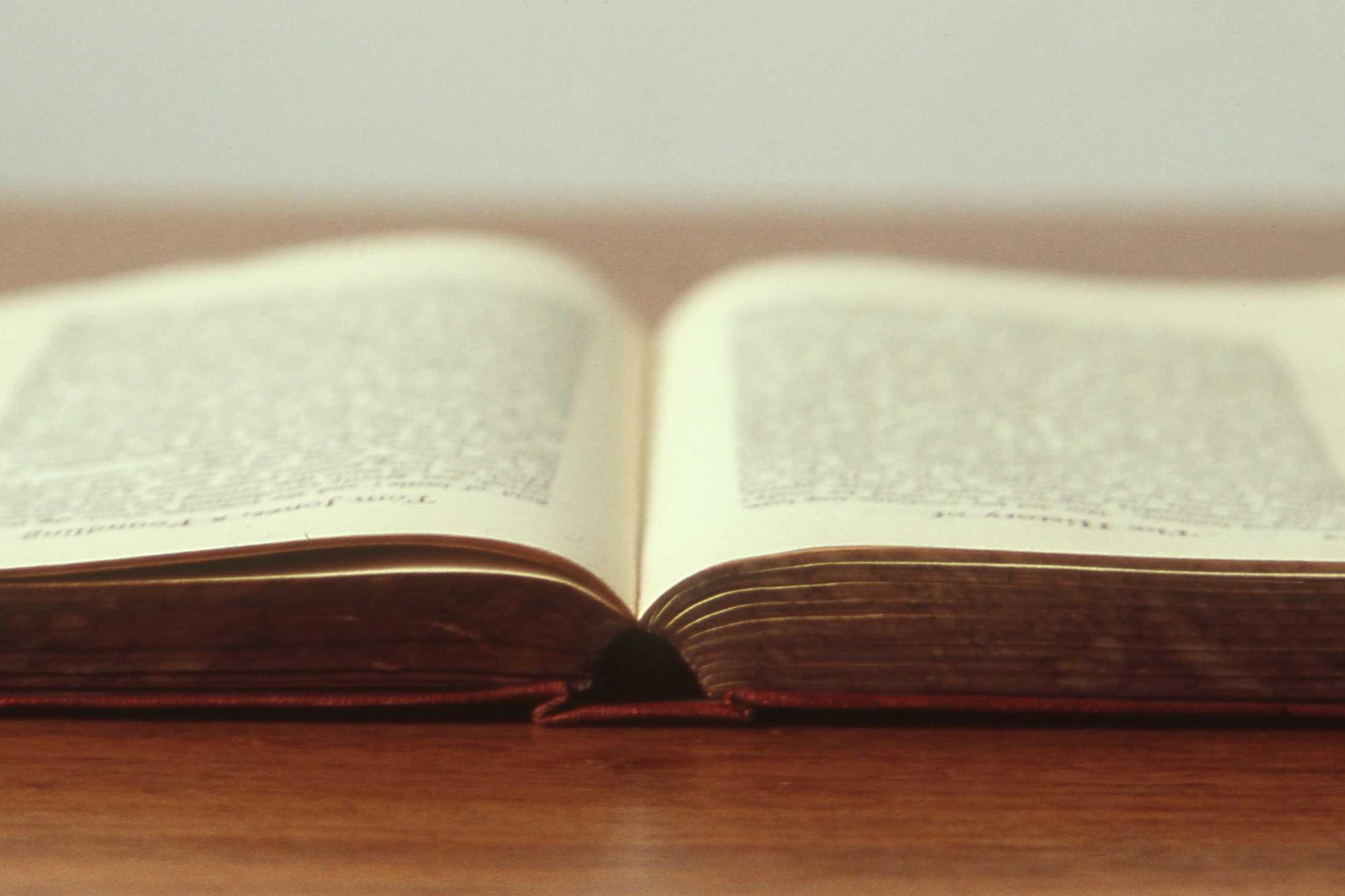 An old open book resting on a wooden table